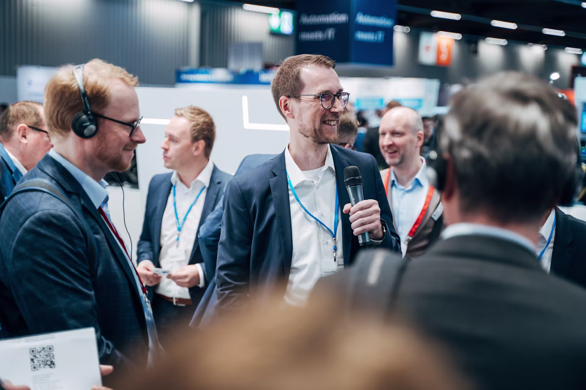 Janitza-Mitarbeiter hält eine Präsentation mit Mikrofon für Messebesucher auf einer Fachmesse