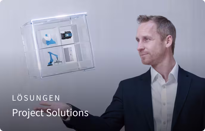 Ein Mann in Businesskleidung präsentiert ein schwebendes, transparentes Würfelmodell mit technischen Komponenten, daneben steht der Text „Lösungen – Project Solutions“.