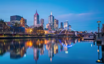 City skyline at sunset with buildings reflected in the water